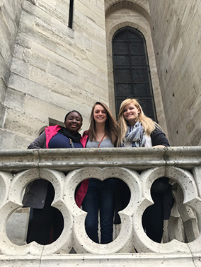 Photo from below of students on a balcony