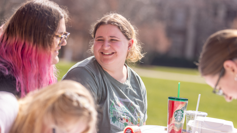 Students managing a table for International Women's Day