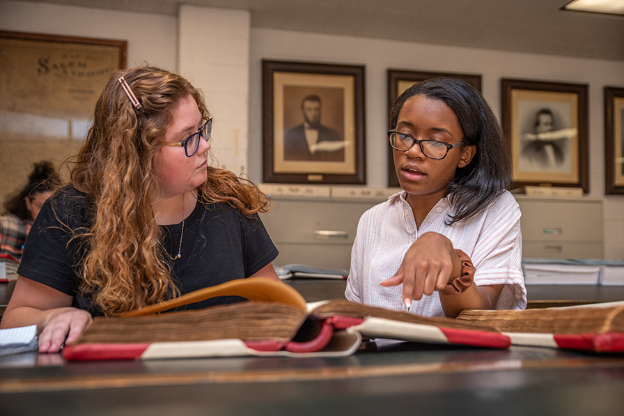 Two students reading archieves