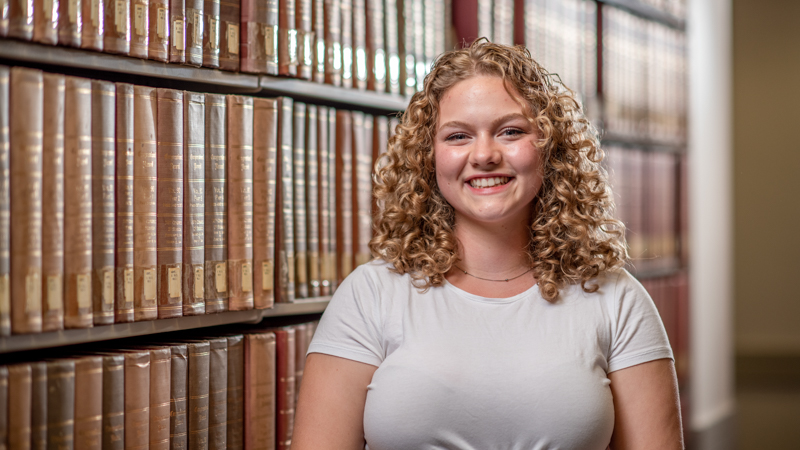 Student standing in front of records for the Center for Studying the Structures of Race