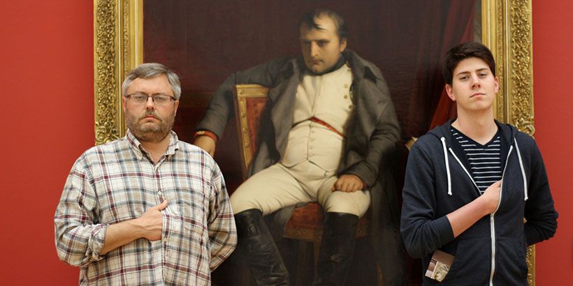 Photo of Professor Rob Willingham with a student by a portrait