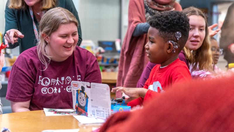 Student working with a child with a cochlear implant