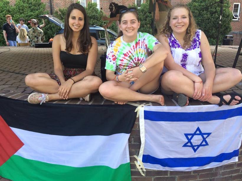 Students posing by flags from different countries