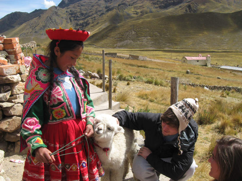 Students petting a lamb in a Latin American country