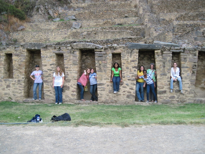 Students posing for pictures inside ruins in a Latin American country