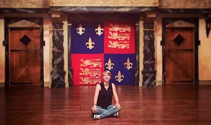 Madison Little sitting on the stage of Blackfriars Playhouse