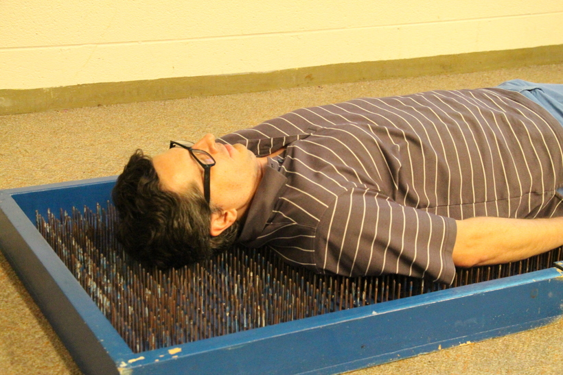 Professor laying on a bed of nails