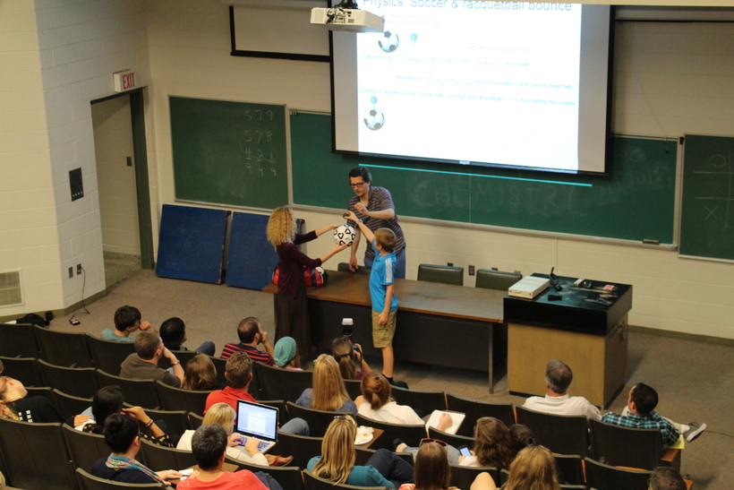 Students trying a magic trick with a professor