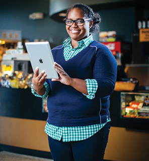 Taylor Ferebee smiles while holding a tablet in a movie theater