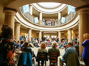 People gather in chairs around a rotunda for a teach-in event