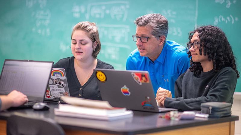 Dan Robb with two students