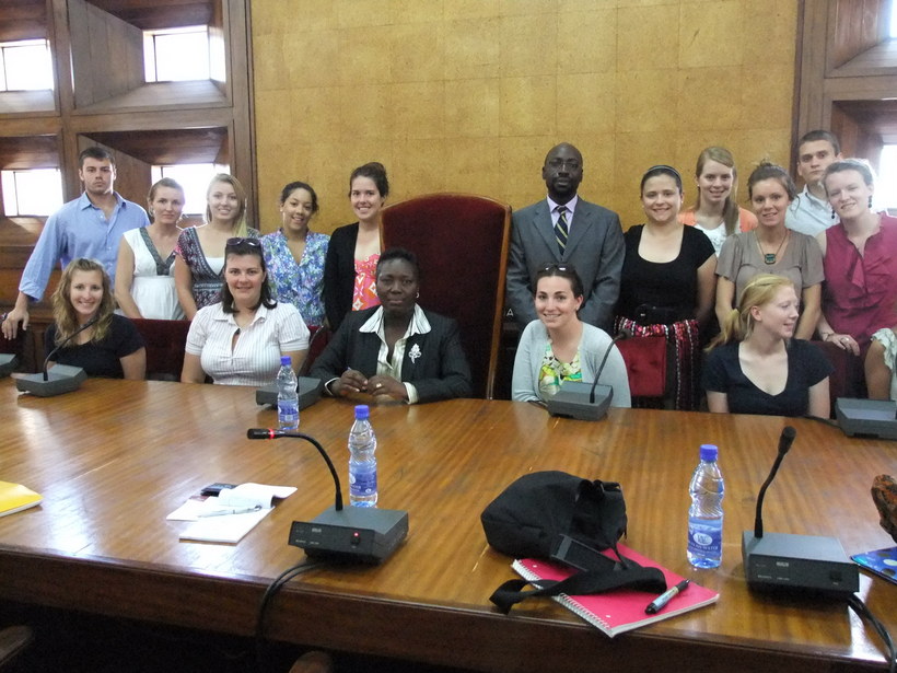 A group of students and Dr. Rubongoya in a government building