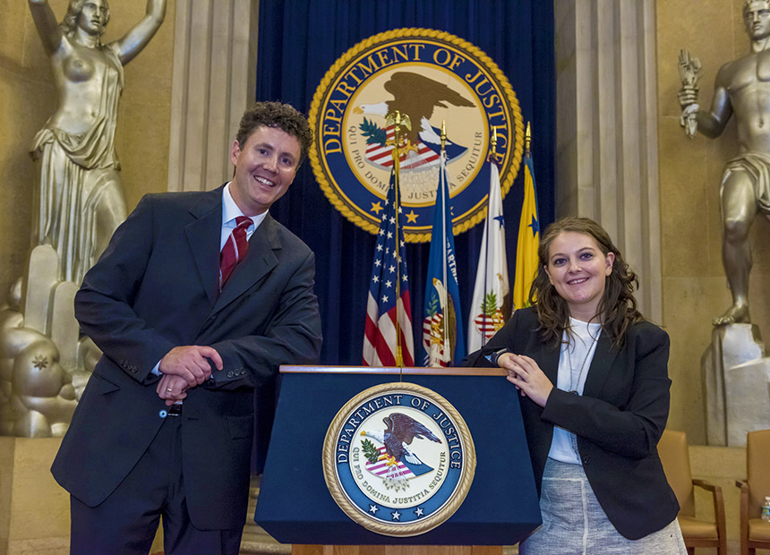 Students leaning on the podium for the Department of Justice