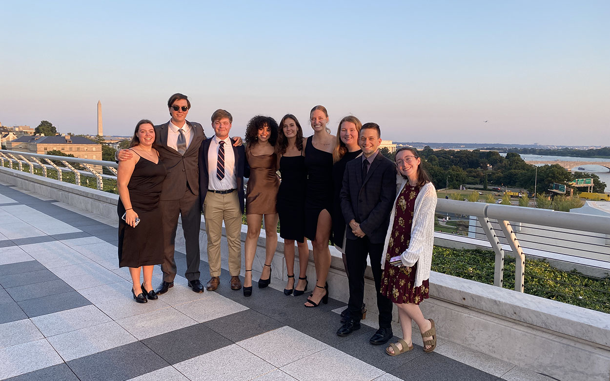 Group of Washington Semester students on a balcony overlooking the Washington Monument