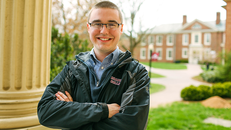 Ben Cowgill stands with the Roanoke campus in the background.