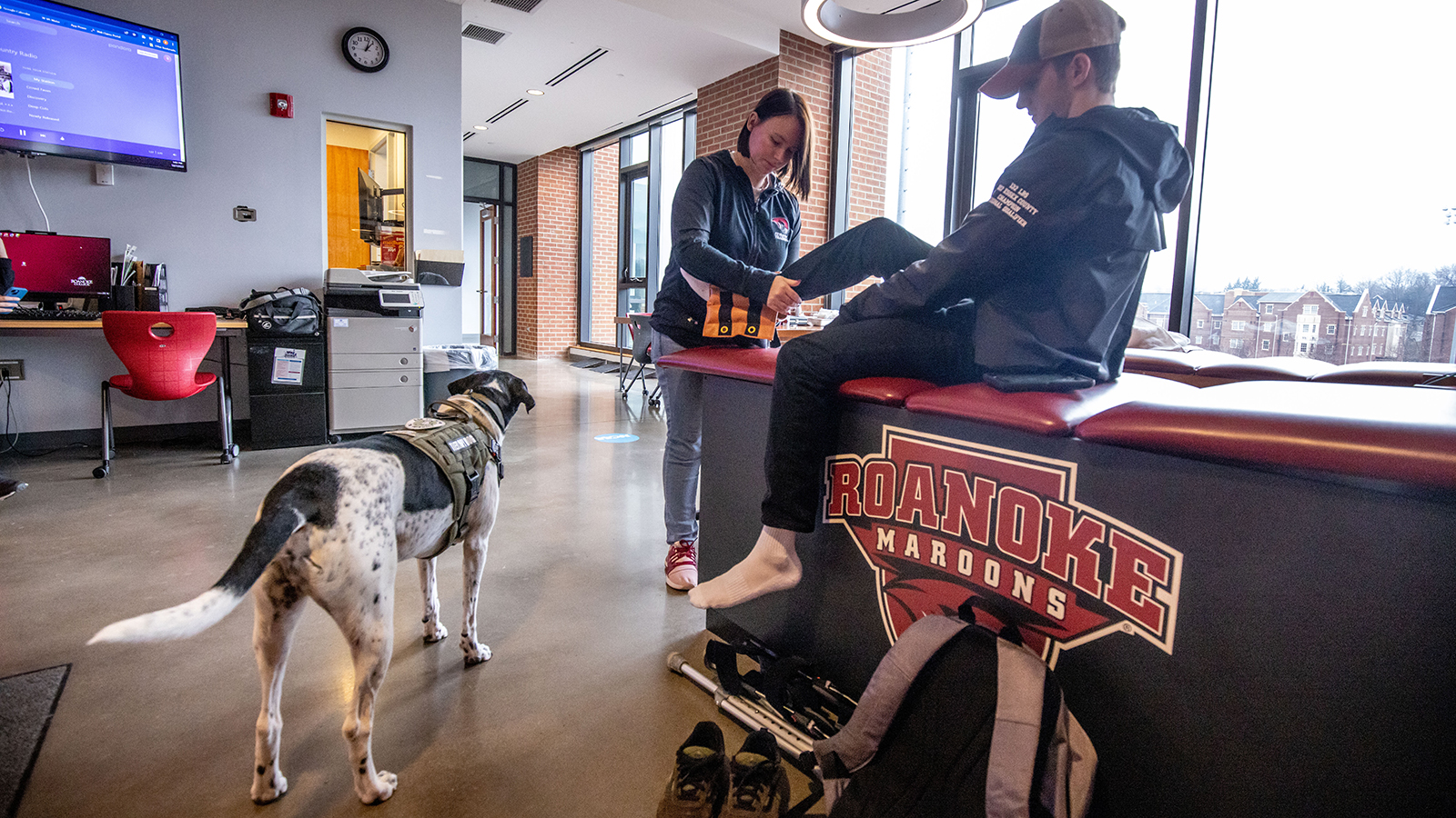 faculty working with student in athletic training center