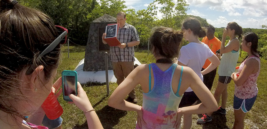 Students gather around to listen to Professor Morris in the field