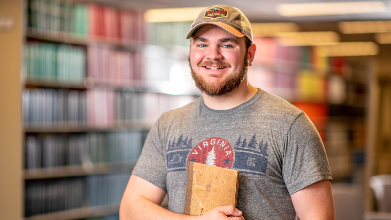 Student holding a file in the library