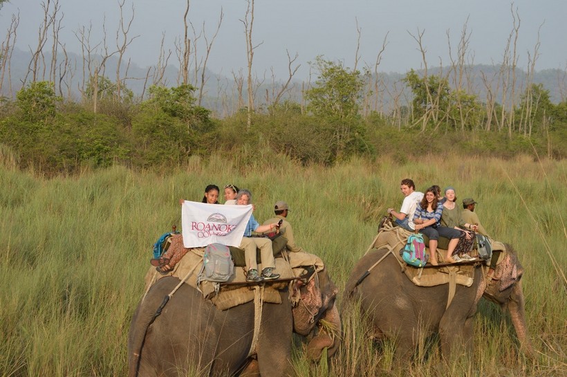 Students on elephants holding a Roanoke College banner