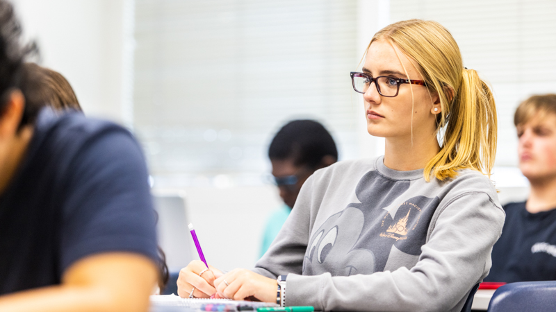 Anna Markey '26 taking notes in sociology class