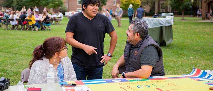 students and professors talk during a campus event