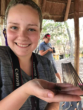 Student holding a spider