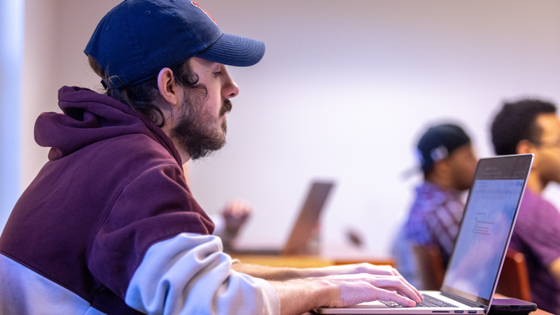 Student using a laptop for a sports management class