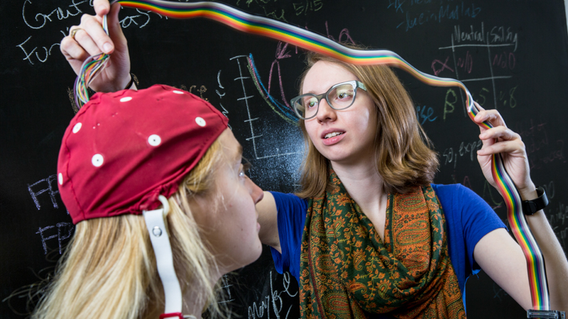 A student demonstrating a neurological monitor on another student