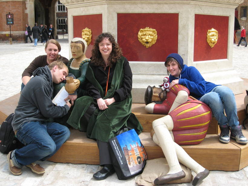 Students posing next to statues