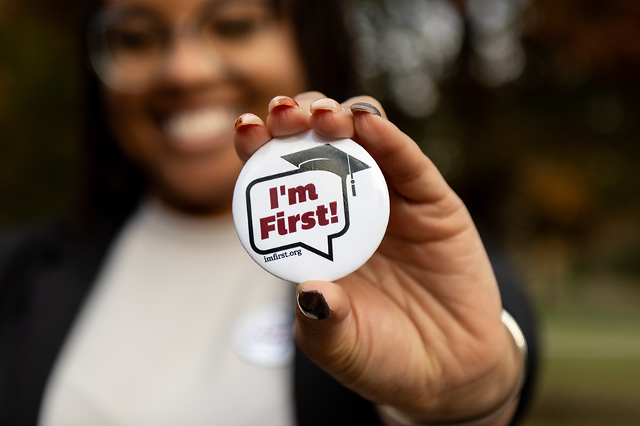 Student holding "I'm First" button