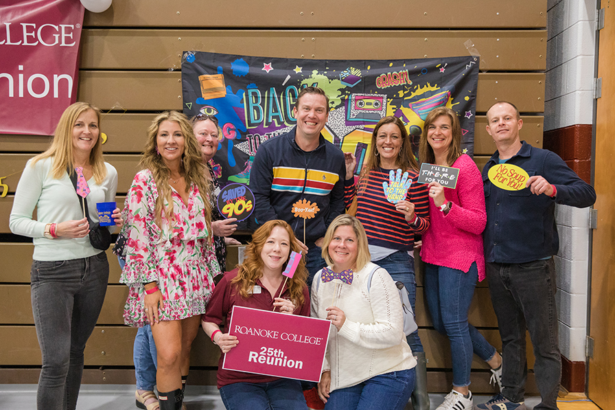 A group of people pose for a photo with a sign that says 25th reunion