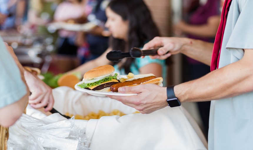 A student getting a plate of food at a picnic