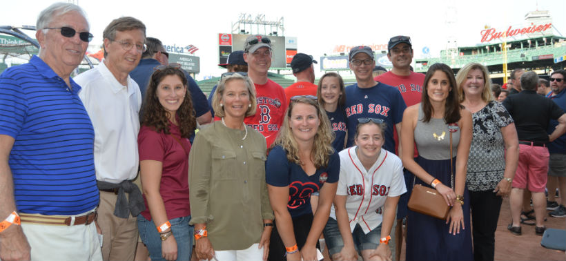Alumni pose for a photo at the Red Sox game with Mrs. Maxey