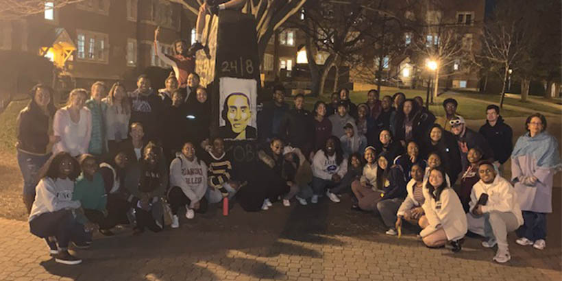 Students gather around a painting of Kobe Bryant 