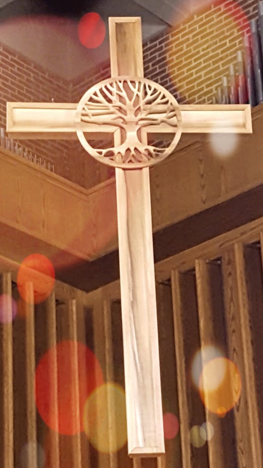 the cross hanging in antrim chapel with the tree of life symbol at the top