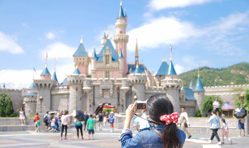 a tourist taking a picture of the castle at disneyland