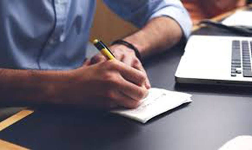 closeup of man's hands as he writes