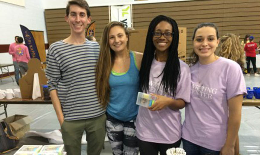 Students wearing shirts from the Writing Center and smiling