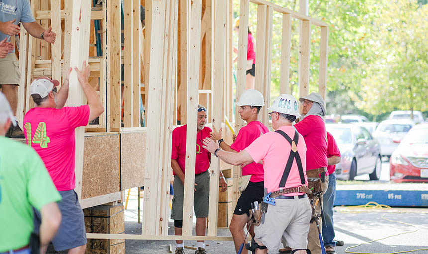 Group of students standing by a house being built