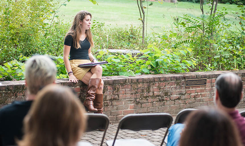 a senior reading one of her works to an audience