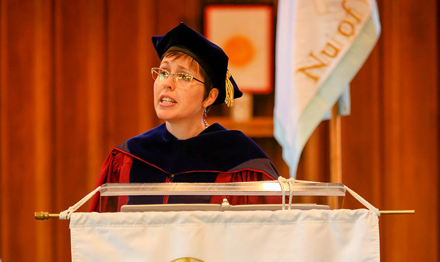 Dr. Warden speaking at a Phi Beta Kappa event behind a lectern