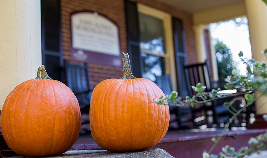 Photo of two pumpkins in front of a campus building