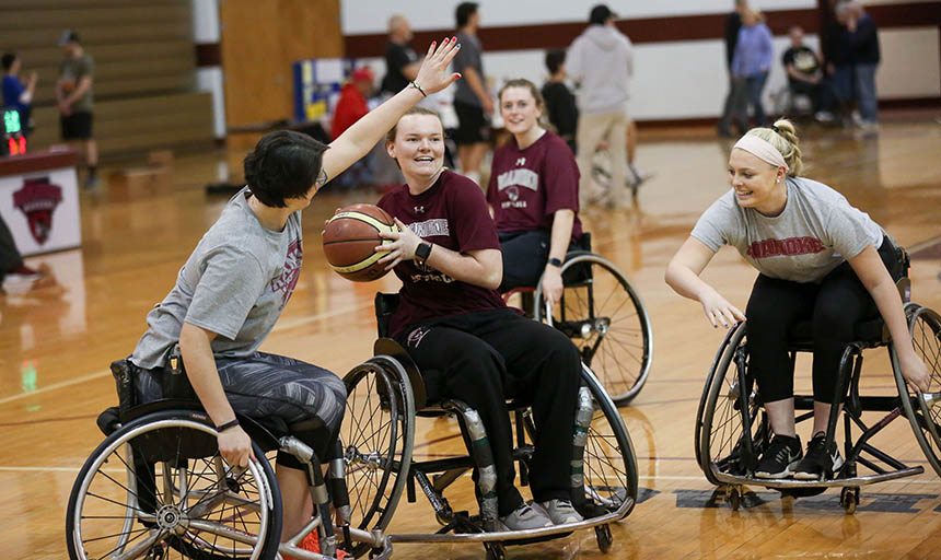 Students playing basketball in wheelchairs
