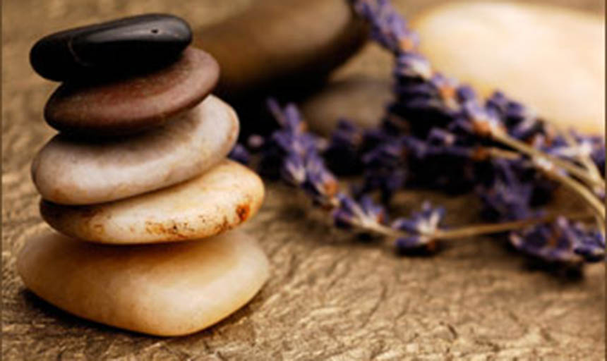 A stack of smooth rocks and a sprig of lavender
