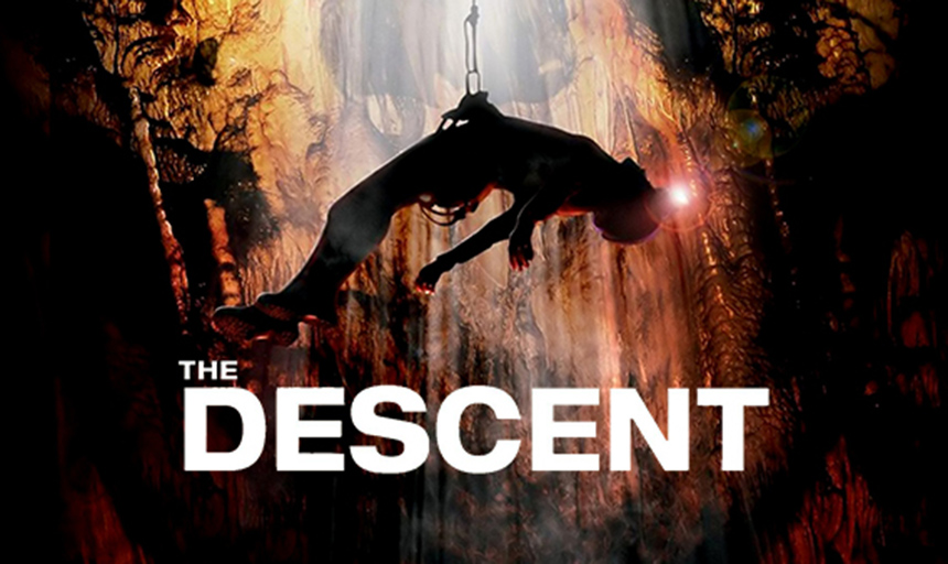 The descent. Picture of a person hanging in a cave.