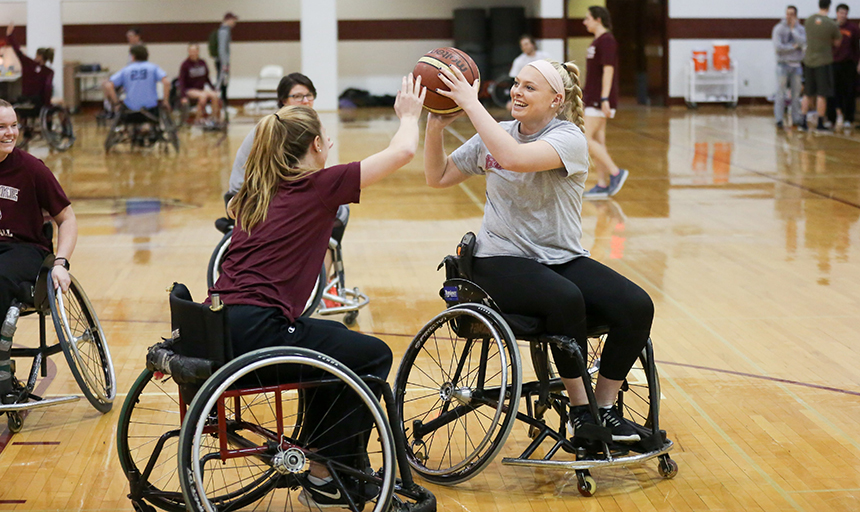 two students playing wheelchair basketball