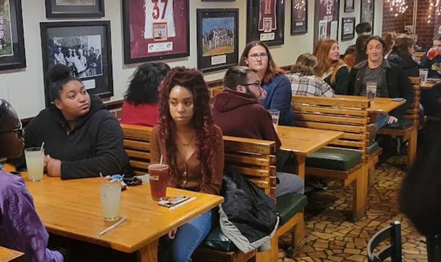 students gathered in restaurant booths at past theology on tap event