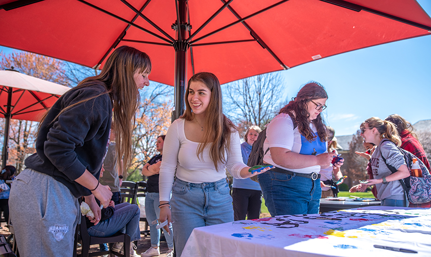 Students adding handprints to the class of 2023 banner 