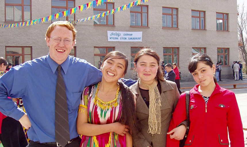 A professor and students smile for a picture during an overseas trip