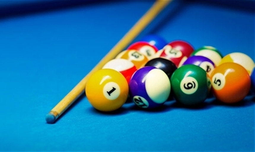 A cue stick and billard balls on a billard table